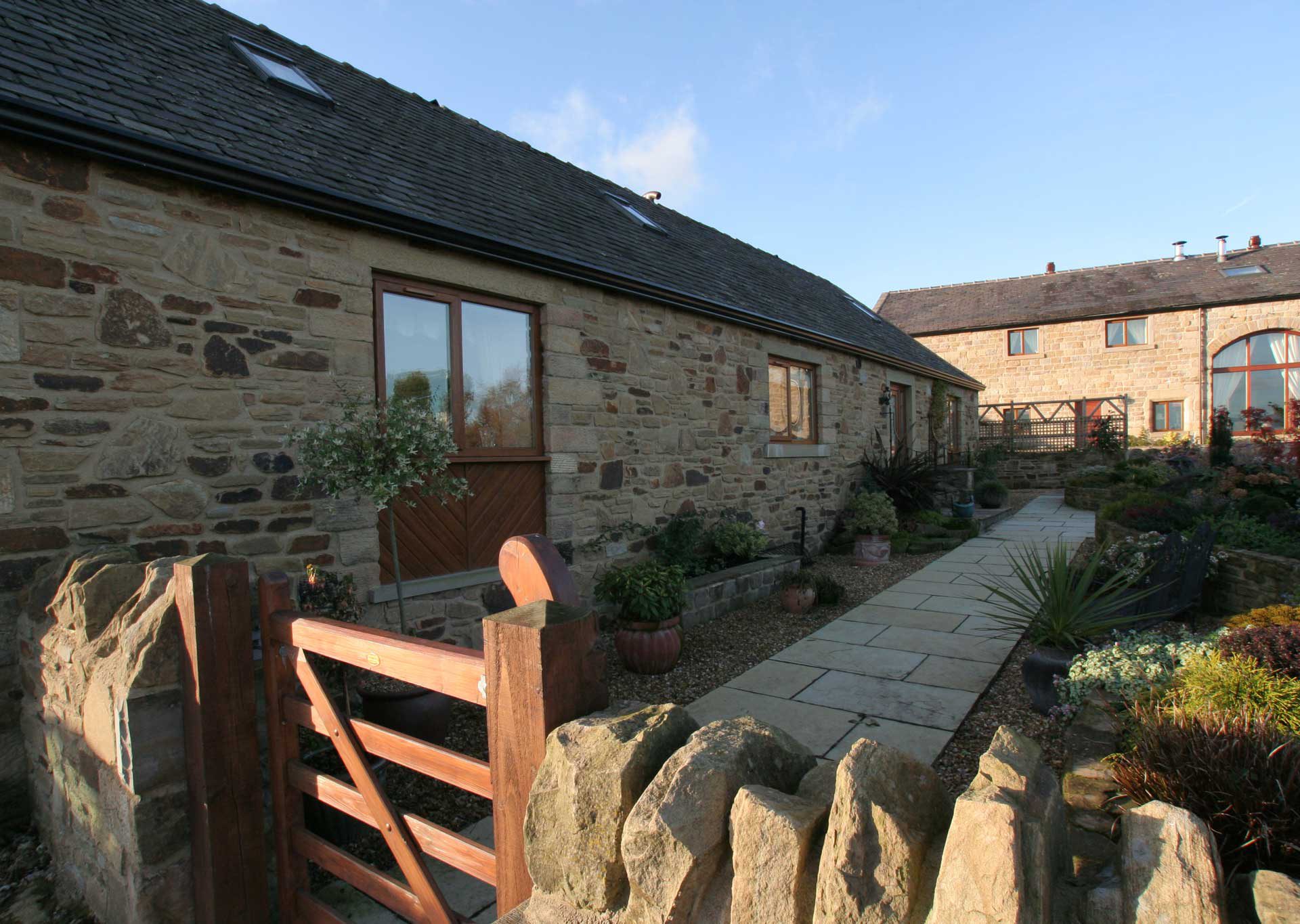 Tilt and Turn windows in country home with shrub garden and slab pathway