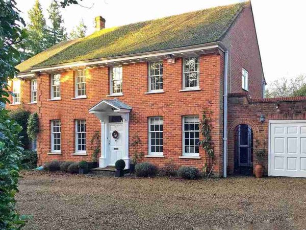 Brick home with white double glazed sliding sash windows 