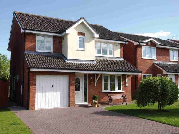 Large brick home fitted with tilt and turn windows and a garage and driveway