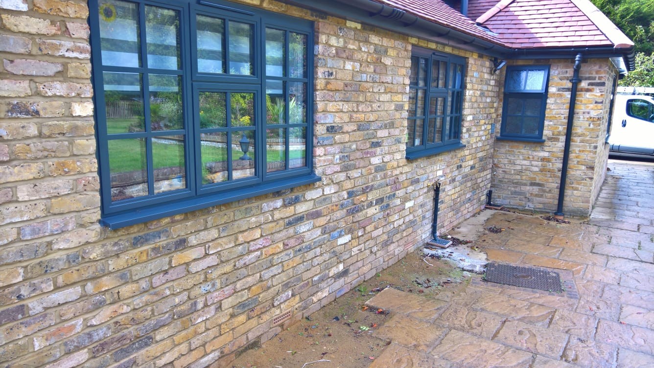 stone home with black aluminium heritage windows Portsmouth